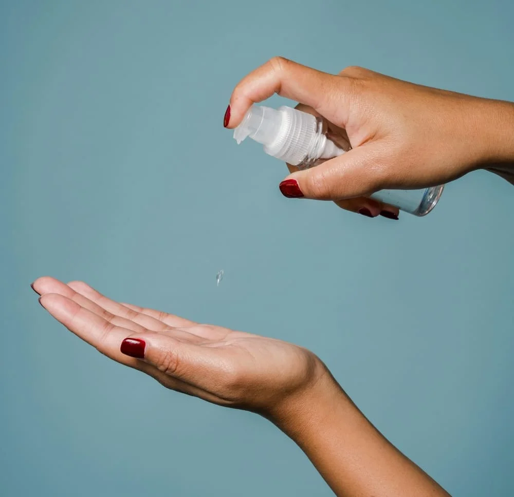 a imagem mostra duas mãos femininas aplicando sérum para cabelos na palma de uma das mãos. 